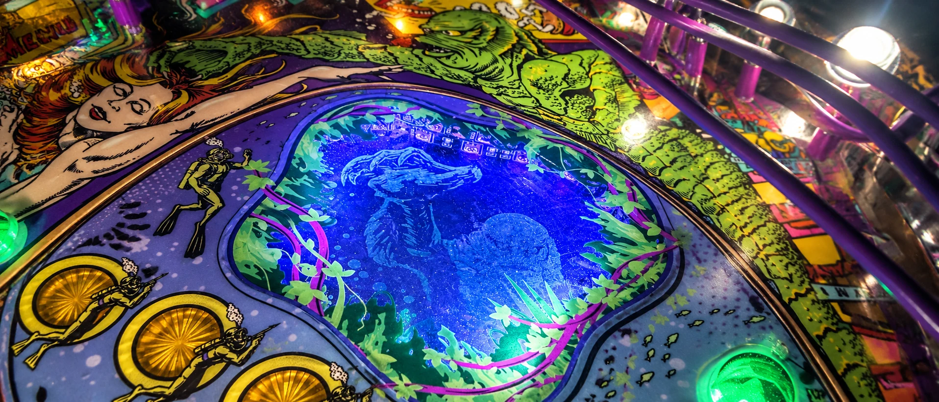 Creature from the Black Lagoon pinball playfield illuminated with blue and green lights